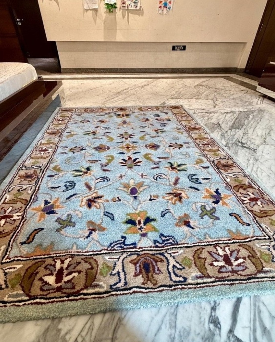 Light blue floral hand tufted wool rug in a customer's bedroom in Noida