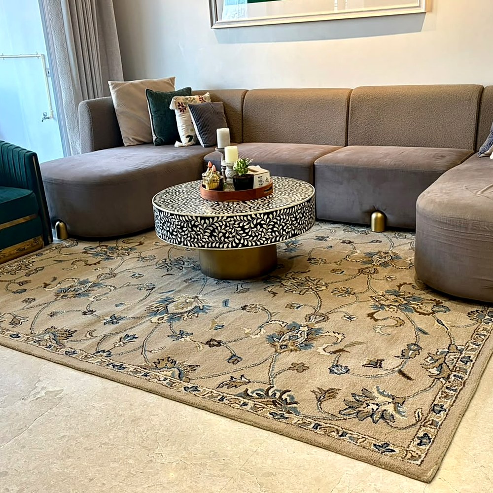 Taupe and blue floral hand tufted wool rug in a customer's living room in Noida